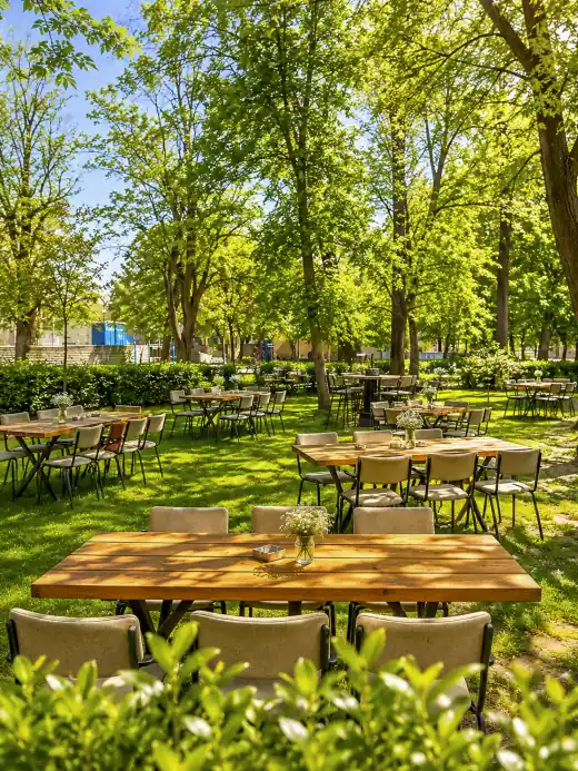 Outdoor garden with tables and trees at KASAPI restaurant in Plovdiv